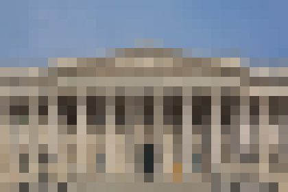 Classical stone building with tall columns and a triangular pediment under a clear blue sky.