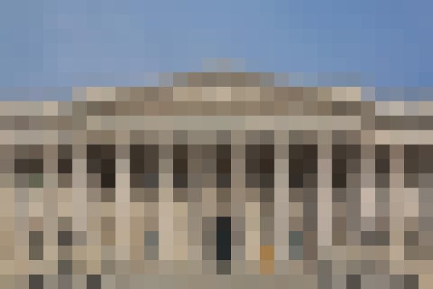 Classical stone building with tall columns and a triangular pediment under a clear blue sky.