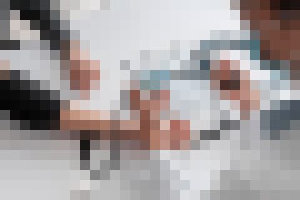 Blurred group of people standing together in a bright indoor setting, suggesting a team or friends photo