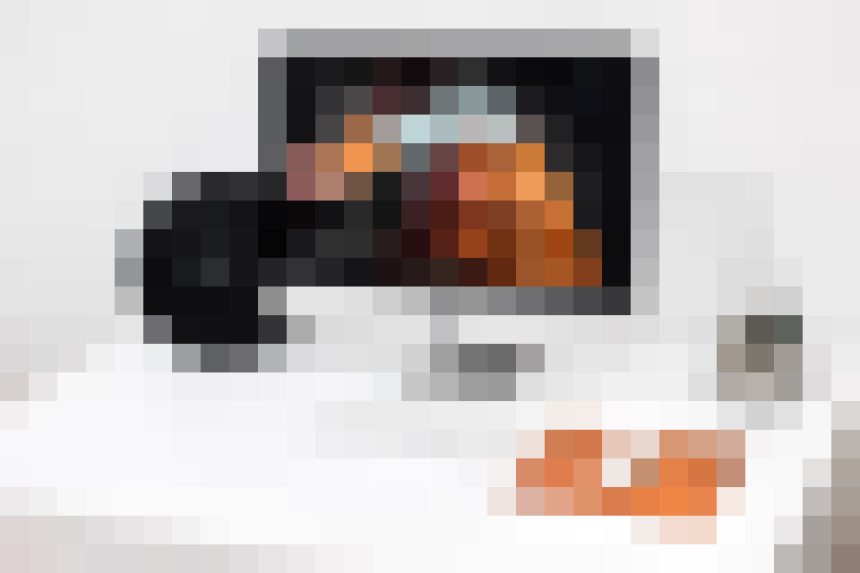 Desktop computer monitor on a white desk displaying a video call.