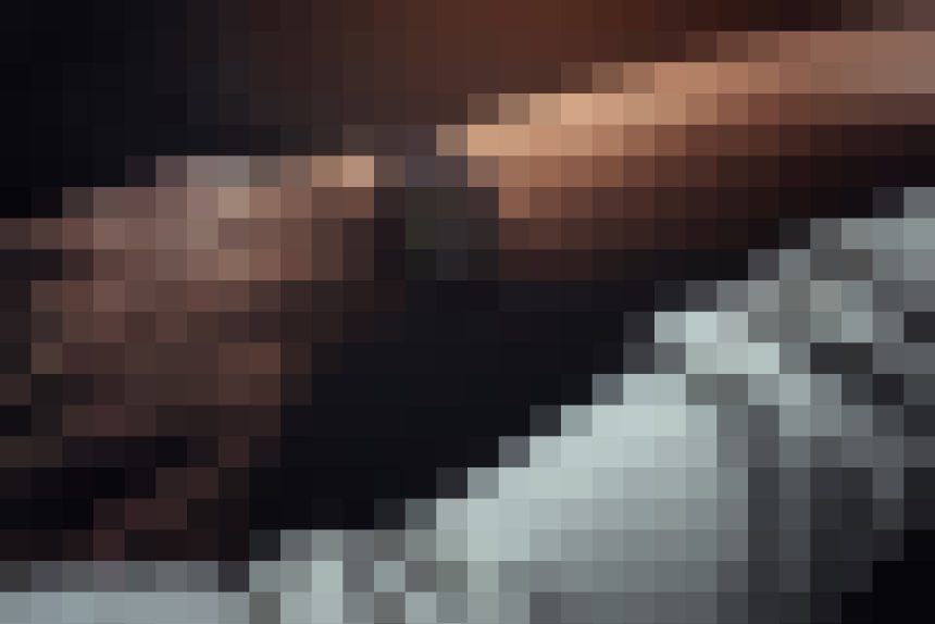 Heavily pixelated image with dark brown tones on top and gray blocks toward the bottom; no discernible subject or detail.